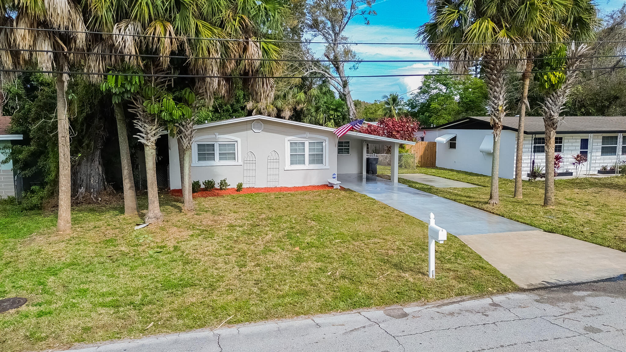 602 Azalea Avenue Fort Pierce, FL 34982 - Photo 17 of 20 a view of a house with a small yard plants and palm trees