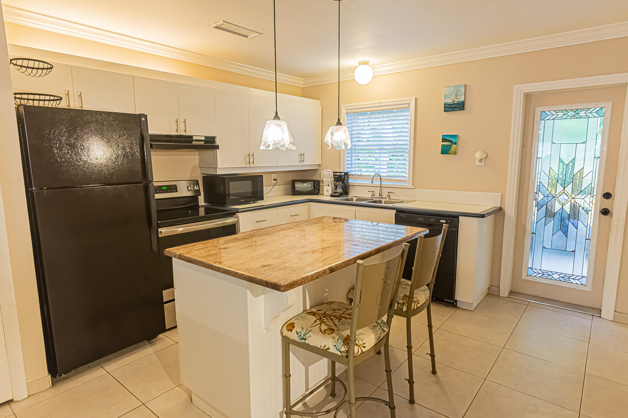 602 Azalea Avenue Fort Pierce, FL 34982 - Photo 6 of 20 a kitchen with stainless steel appliances granite countertop a sink a refrigerator and a wooden cabinets