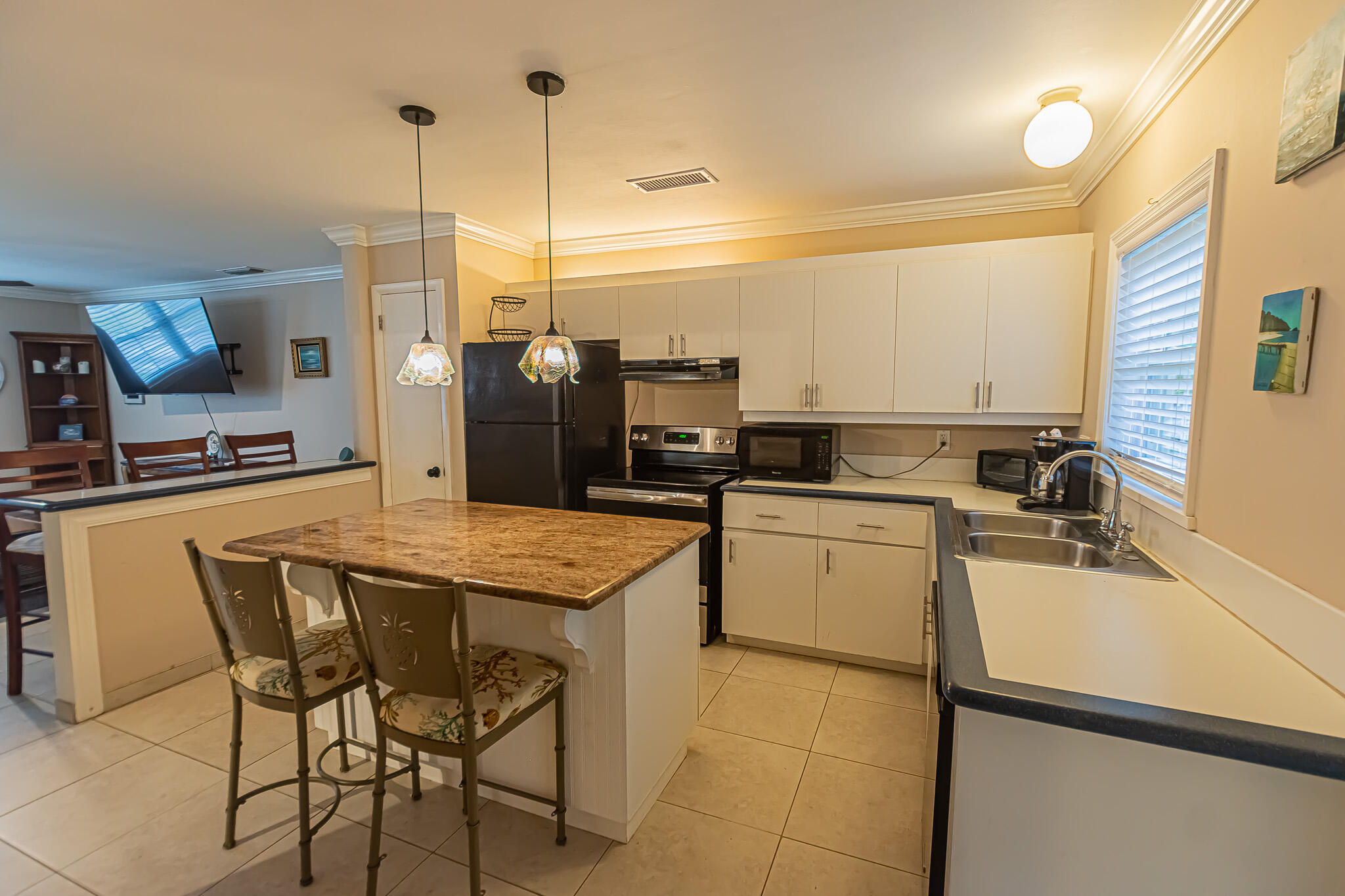 602 Azalea Avenue Fort Pierce, FL 34982 - Photo 7 of 20 a kitchen with a sink a stove and chairs