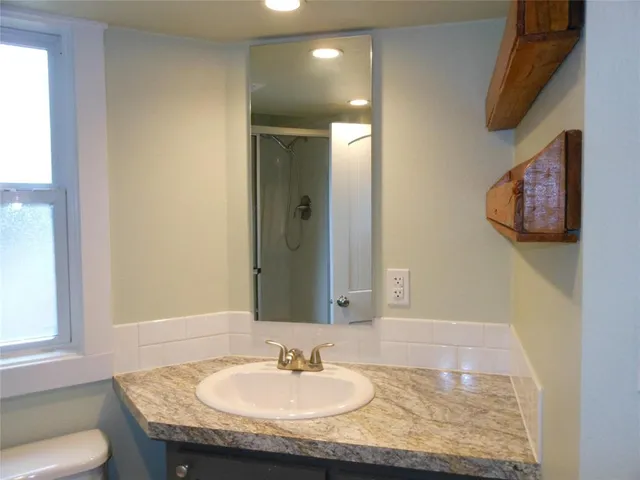 a bathroom with a granite countertop sink and a mirror