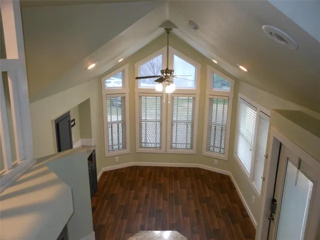 a view of a livingroom with wooden floor and staircase