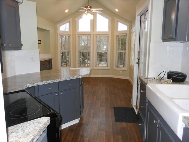 a spacious bathroom with a granite countertop sink a mirror and a shower