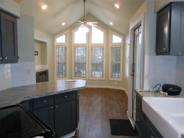 a view of a kitchen with a sink wooden cabinets and a window