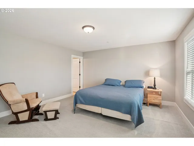 a bedroom with a bed chair and window