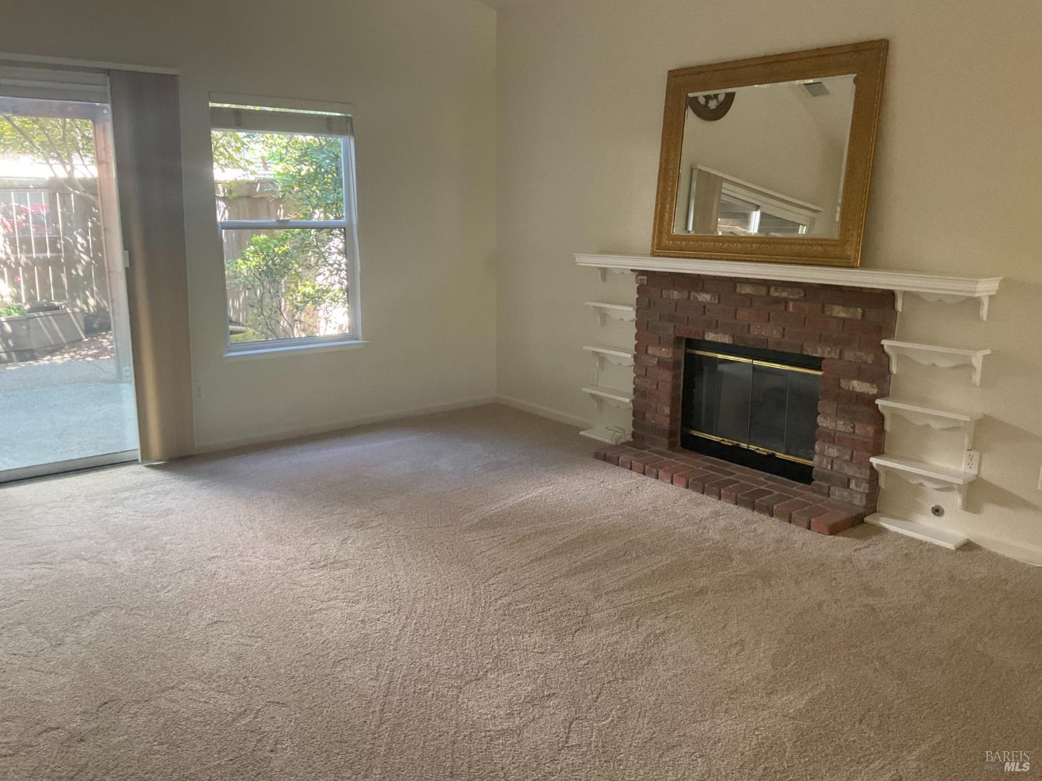 9131 Benny Goodman Way Windsor, CA 95492 - Photo 9 of 27 an empty room with a fireplace and windows