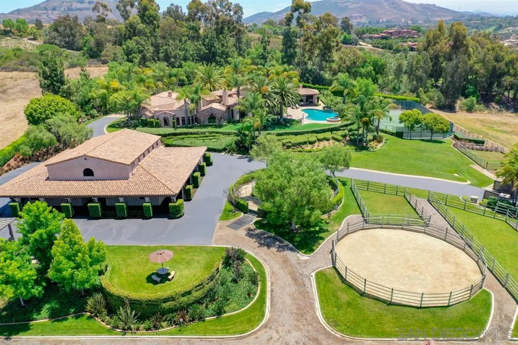 an aerial view of a house with outdoor space and swimming pool