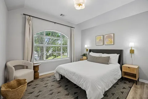 a bedroom with a bed and a couch with window