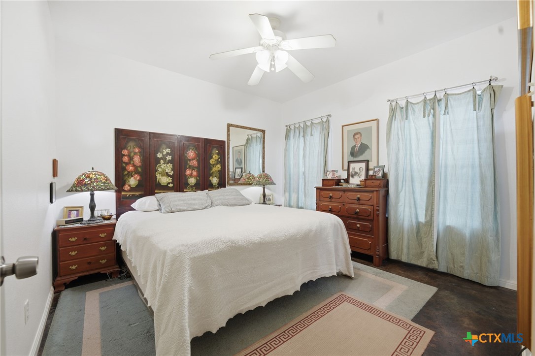 3075 Rustler Canyon Lake, TX 78133 - Photo 22 of 48 a bedroom with a large bed and a chandelier