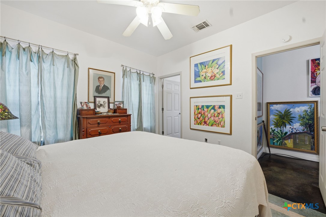 3075 Rustler Canyon Lake, TX 78133 - Photo 23 of 48 a bedroom with a large bed and a chandelier