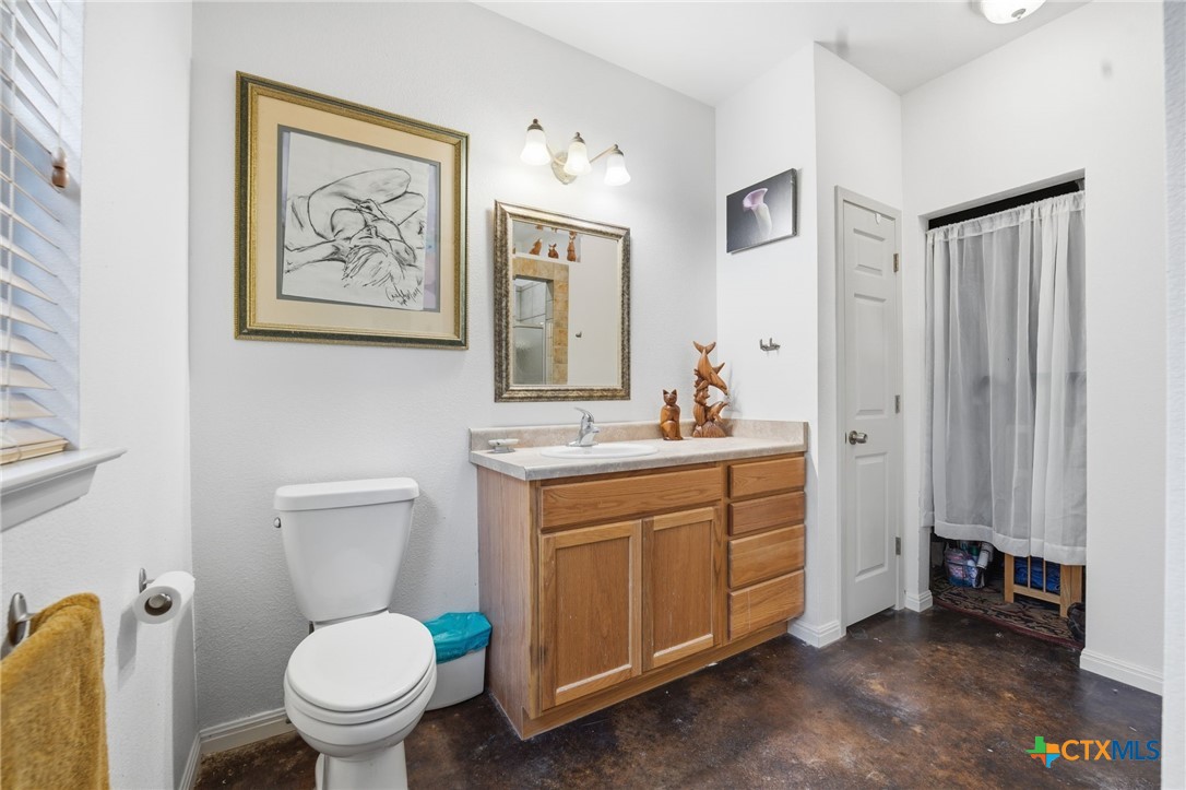 3075 Rustler Canyon Lake, TX 78133 - Photo 26 of 48 a bathroom with a toilet a sink and a mirror
