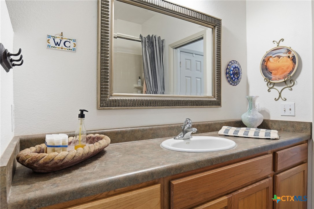 3075 Rustler Canyon Lake, TX 78133 - Photo 34 of 48 a bathroom with a granite countertop sink and a mirror