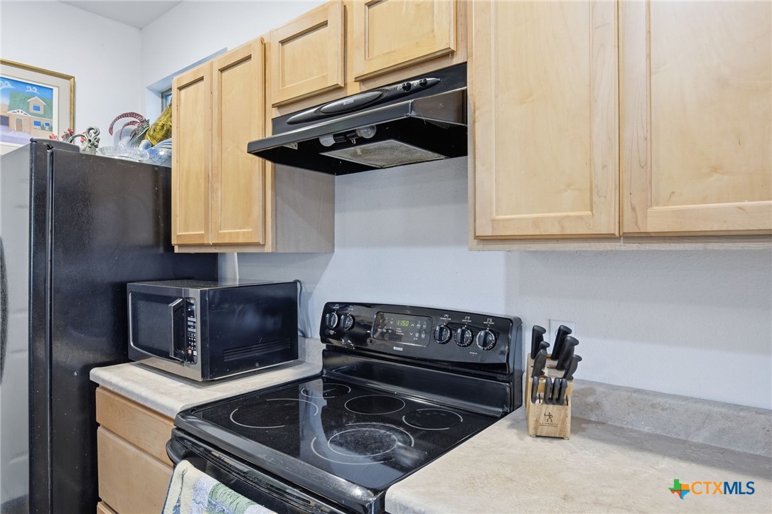 3075 Rustler Canyon Lake, TX 78133 - Photo 10 of 48 a kitchen with stainless steel appliances granite countertop a stove and a refrigerator