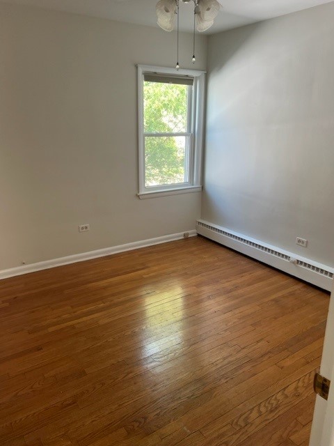 5454 West Windsor Avenue, Unit 2 Chicago, IL 60630 - Photo 7 of 8 an empty room with wooden floor and windows