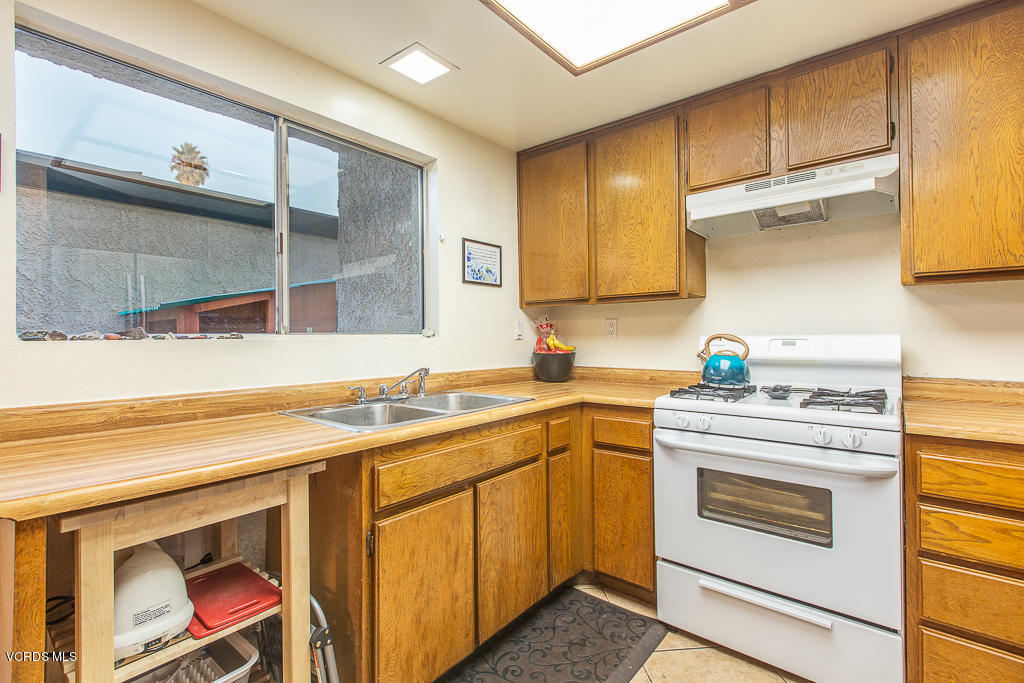 5149 Perkins Road Oxnard, CA 93033 - Photo 26 of 40 a kitchen with a sink stove and cabinets