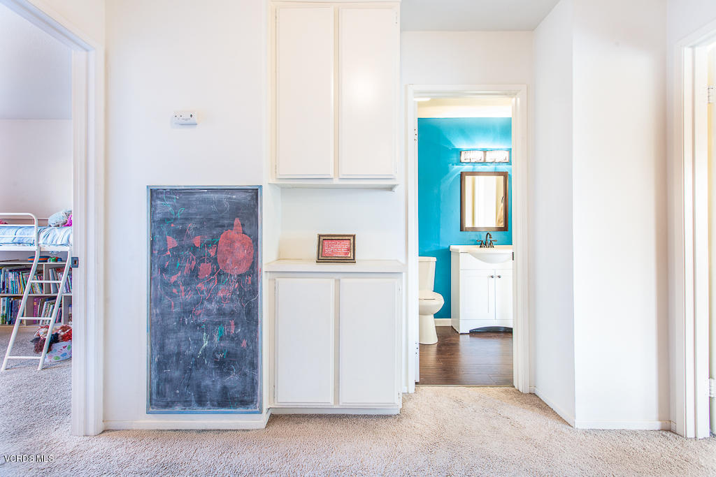 5149 Perkins Road Oxnard, CA 93033 - Photo 27 of 40 a hallway with cabinet and a painting on the wall