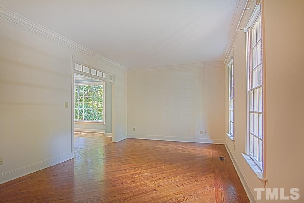 7612 Rainwater Road Raleigh, NC 27615 - Photo 5 of 22 an empty room with wooden floor and windows