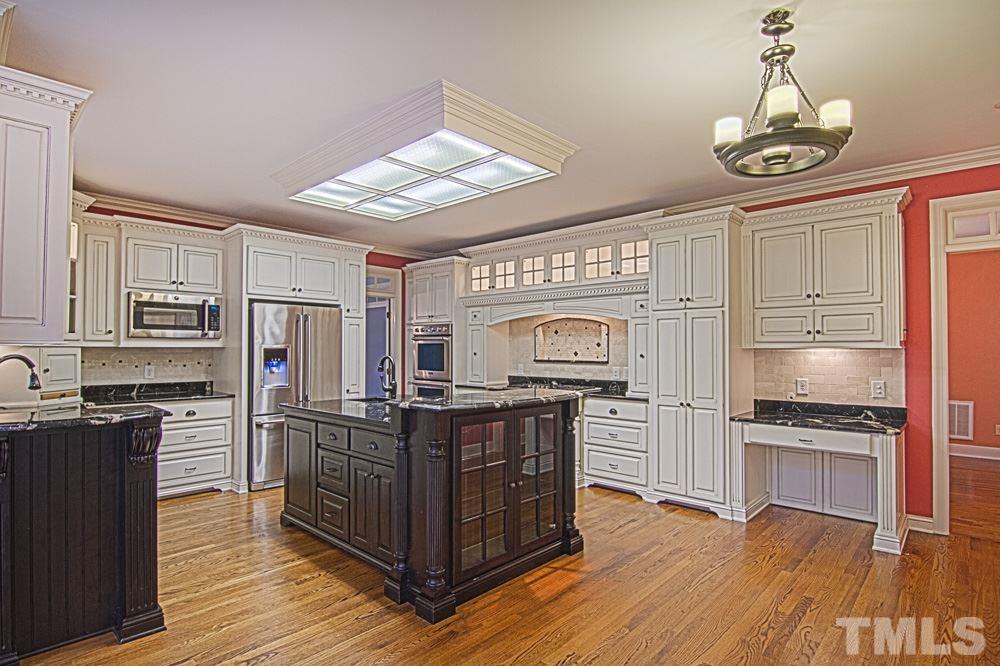 7612 Rainwater Road Raleigh, NC 27615 - Photo 7 of 22 a kitchen with stainless steel appliances a stove refrigerator and cabinets