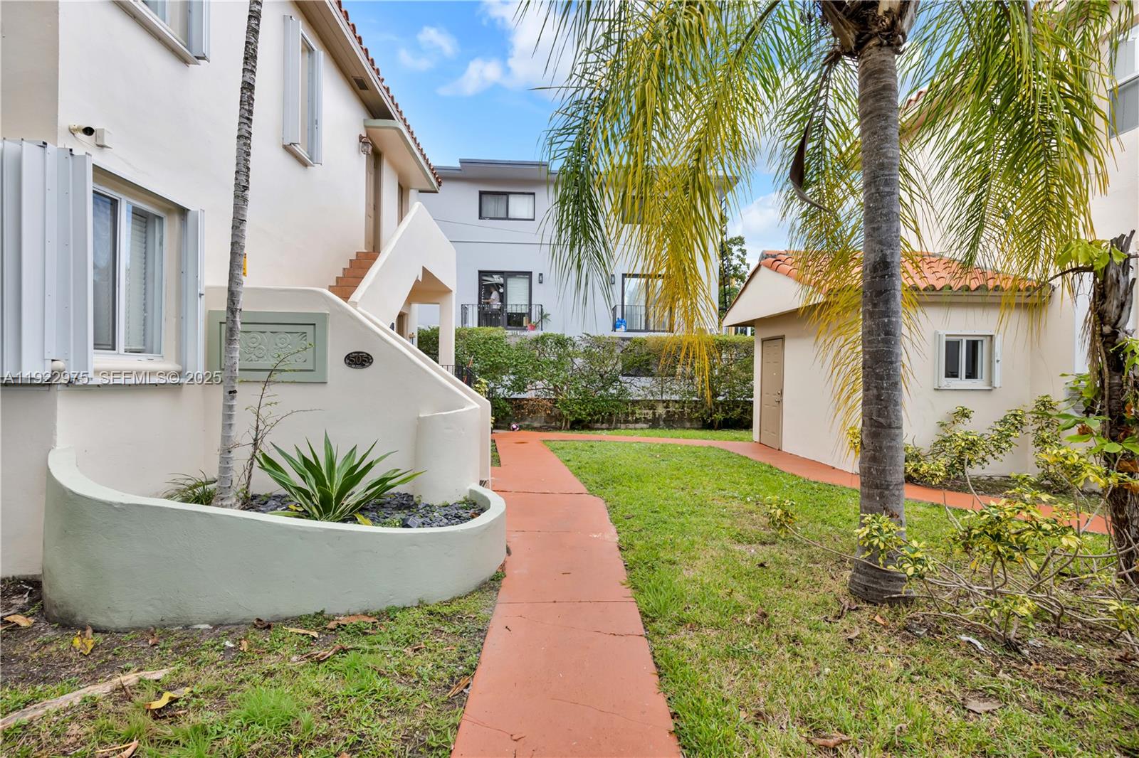 505 Southwest 11th Street, Unit 505 Miami, FL 33129 - Photo 28 of 31 a view of a white house with a small yard and potted plants
