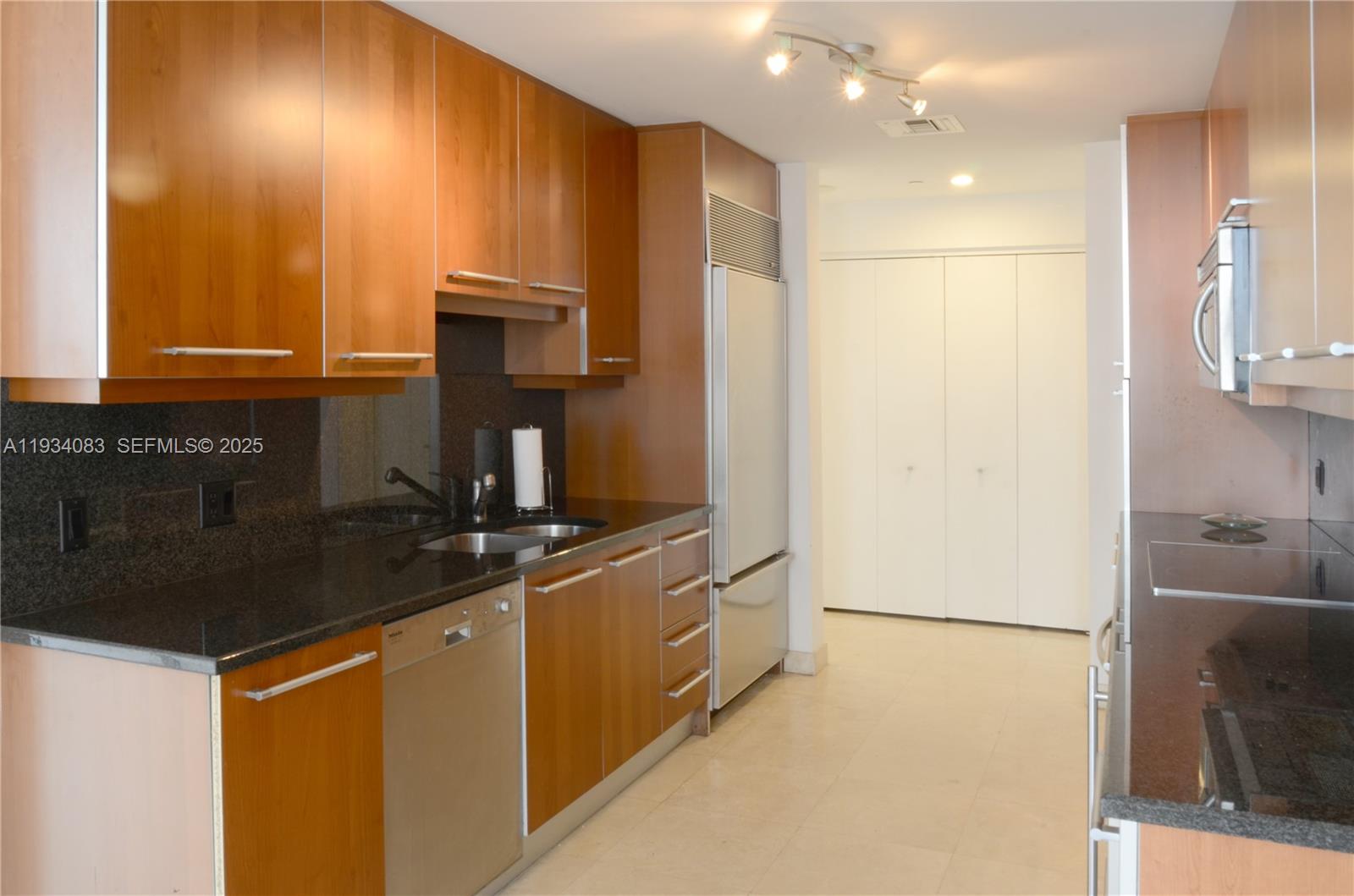 901 Brickell Key Boulevard, Unit 705 Miami, FL 33131 - Photo 18 of 41 a kitchen with kitchen island a sink stainless steel appliances and cabinets