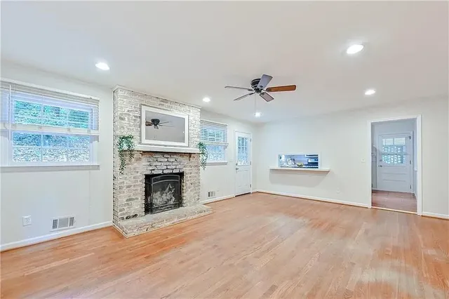 a view of empty room with wooden floor and fireplace
