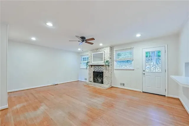 an empty room with windows and fireplace