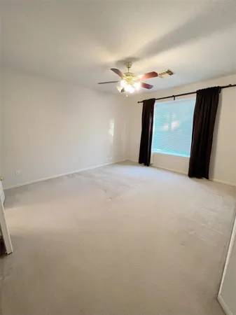 a view of a livingroom with a ceiling fan and window