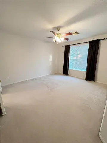 a view of a livingroom with a ceiling fan and window