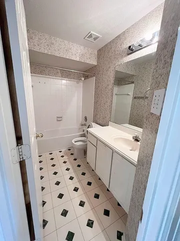 a bathroom with a sink a toilet a shower and a mirror