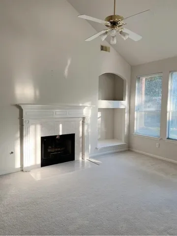 a view of a livingroom with a fireplace and window