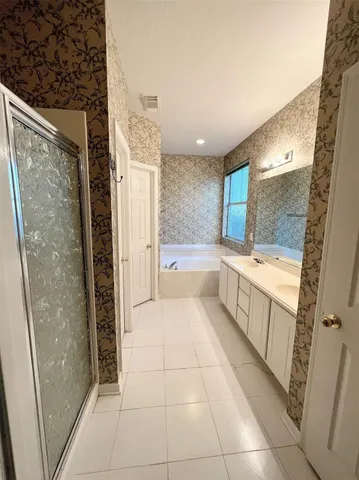a large white bathroom with a tub a sink and a large mirror