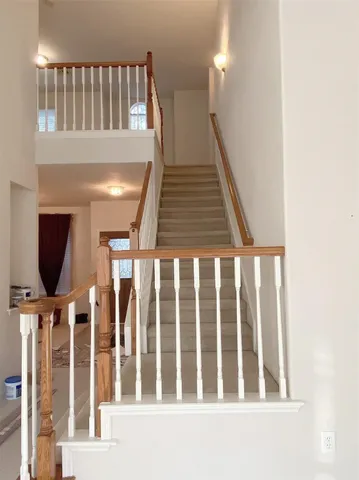 a view of staircase with railing and a window