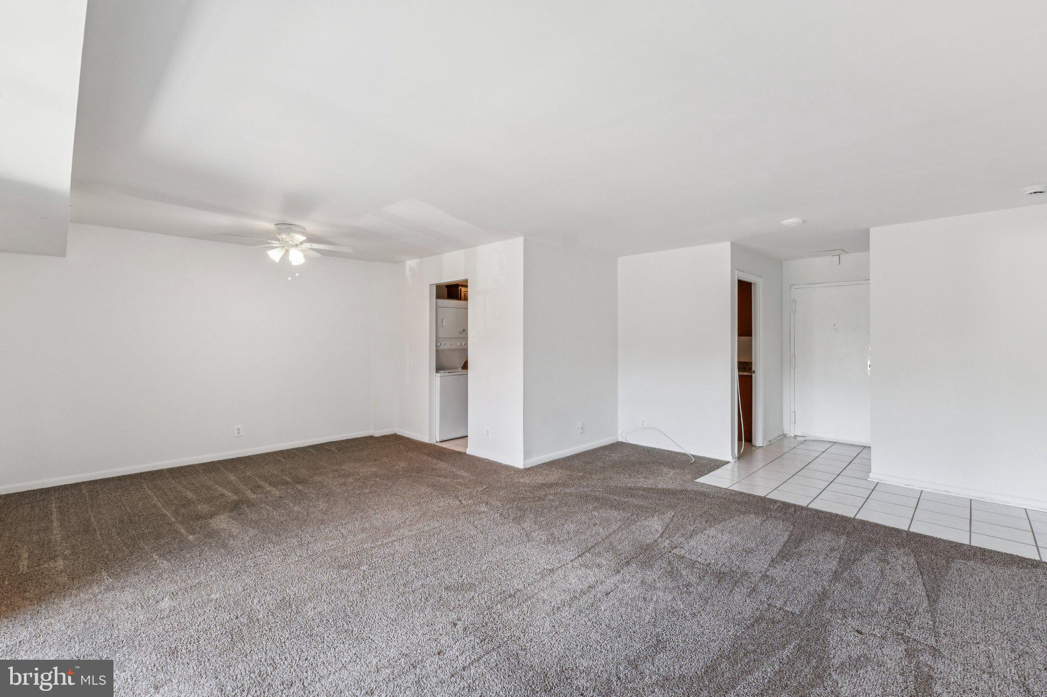 12001 Old Columbia Pike, Unit 209 Silver Spring, MD 20904 - Photo 2 of 27 a view of an empty room with a kitchen