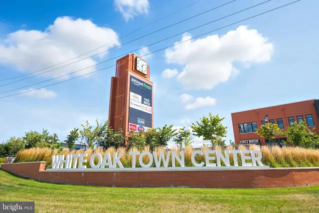 a front view of multi story residential apartment building with yard