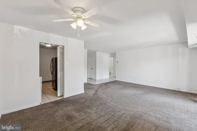 an empty room with a ceiling fan and a window