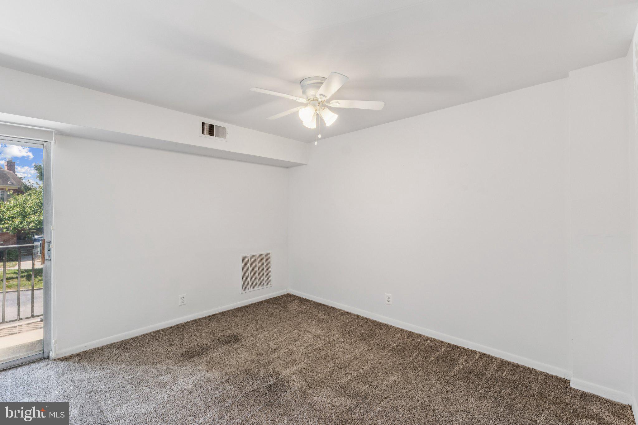 12001 Old Columbia Pike, Unit 209 Silver Spring, MD 20904 - Photo 6 of 27 an empty room with a ceiling fan and a window