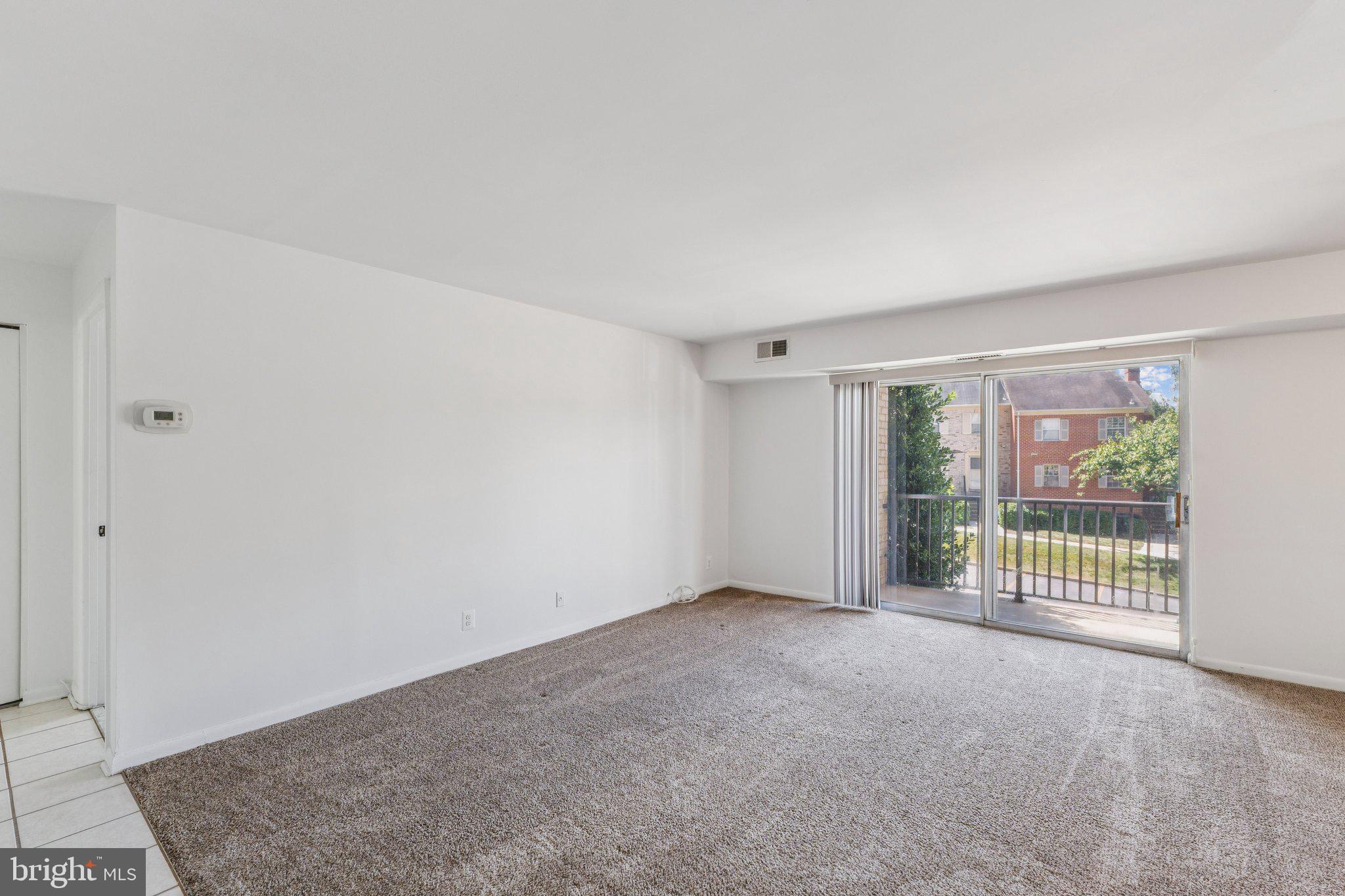 12001 Old Columbia Pike, Unit 209 Silver Spring, MD 20904 - Photo 7 of 27 a view of an empty room with glass door