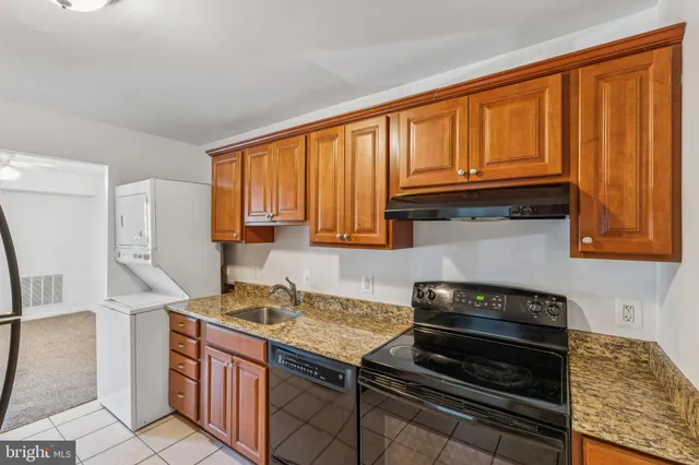 a kitchen with granite countertop wooden cabinets and a stove top oven