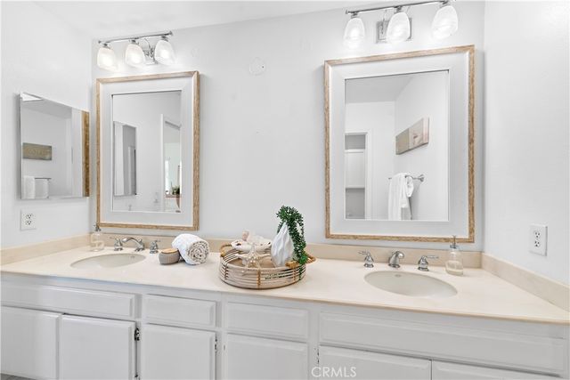 a bathroom with double vanity sinks and a mirror