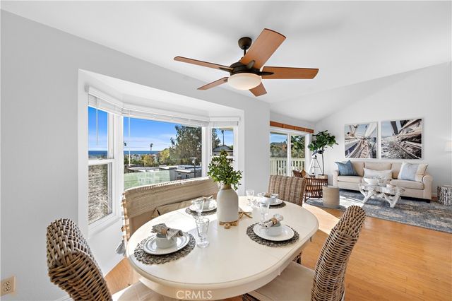 a dining room with furniture a large window and a chandelier