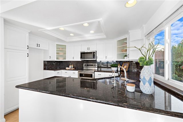 a kitchen with stainless steel appliances granite countertop a sink stove and microwave