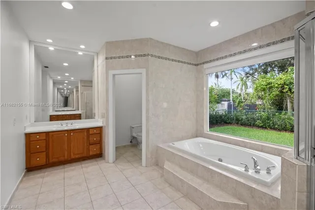 a bathroom with a tub a sink and mirror