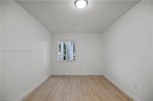 a view of a room that has wooden floor and window
