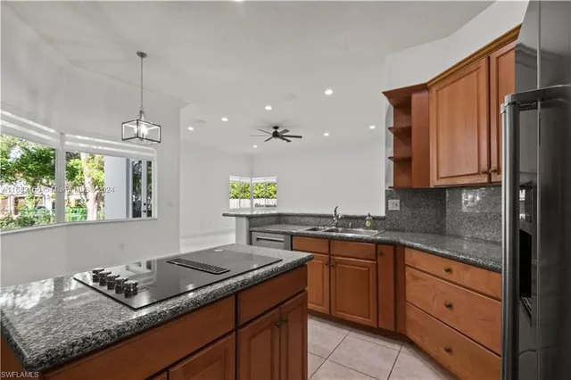 a kitchen with granite countertop stainless steel appliances sink stove and cabinets