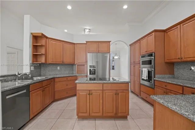 a kitchen with stainless steel appliances granite countertop a sink stove and cabinets