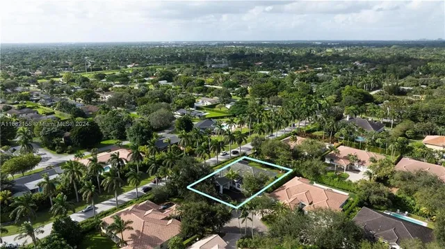 an aerial view of residential houses with outdoor space and trees