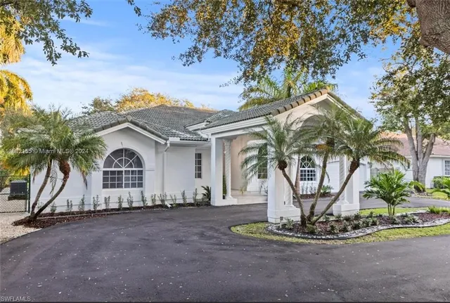 a view of a house with a yard and potted plants
