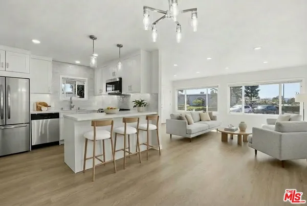 a kitchen with kitchen island granite countertop a sink cabinets and stainless steel appliances