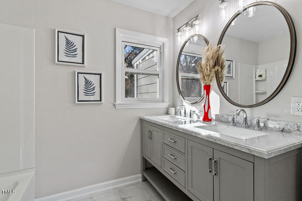 1014 Southerlund Road Garner, NC 27529 - Photo 25 of 36 a bathroom with a granite countertop double vanity and a mirror