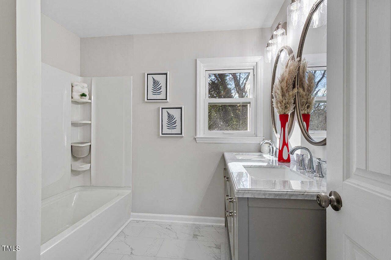 1014 Southerlund Road Garner, NC 27529 - Photo 8 of 36 a bathroom with a sink a mirror and a bathtub