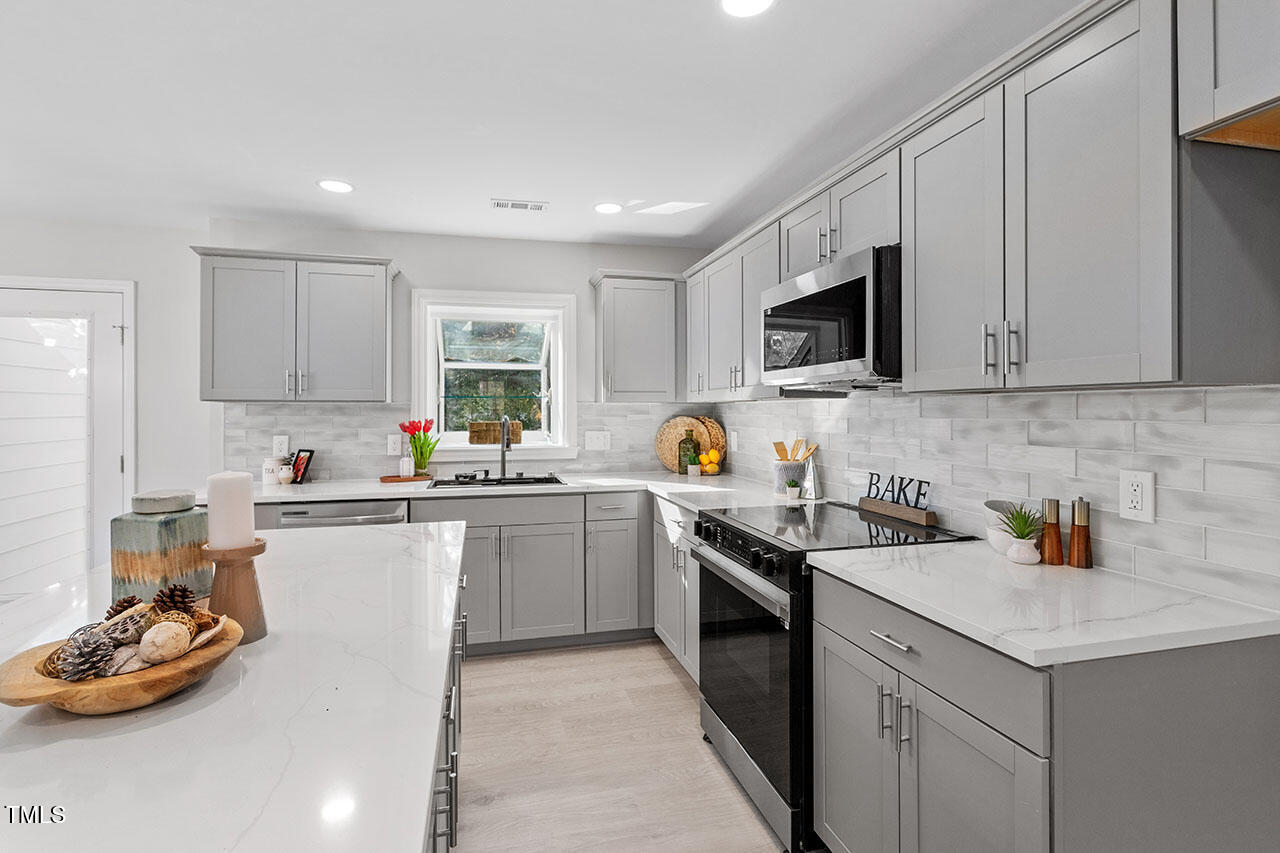 1014 Southerlund Road Garner, NC 27529 - Photo 9 of 36 a kitchen with a sink stove and microwave